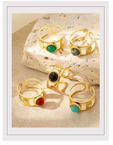 Detail of five vintage gold rings with colorful natural stones on stone background