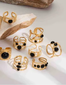Detail of 18K gold stainless steel rings with black stones on natural stones