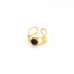 Detailed macro shot of vintage gold ring featuring sunburst texture and black stone