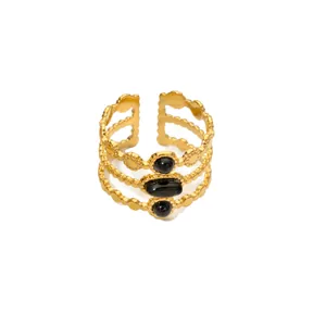 Details eines goldenen Mehrschicht-Rings mit drei schwarzen Edelsteinen und Perldesign