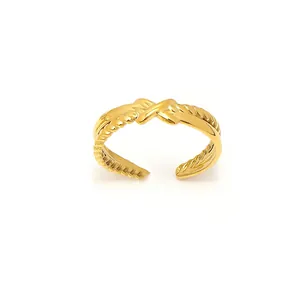 Dettaglio anello geometrico oro 18K con design a corda intrecciata e motivo a croce