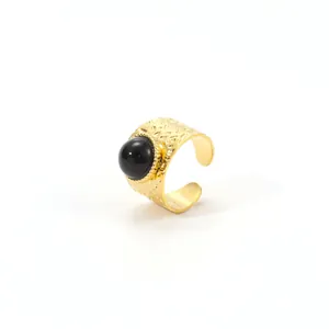 Detail of 18K gold hammered stainless steel ring with a large black round stone inlay