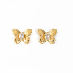Boucles d'oreilles papillon dorées à l'or 18K avec zircons brillants sur fond blanc pur