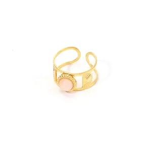 Detail of 18K gold stainless steel ring with pink gemstone and solar ray patterns
