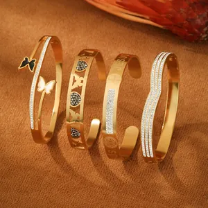 Detail of four gold-plated bangle bracelets featuring Jesus engraving and butterfly accents