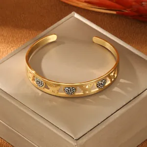 Golden stainless steel cuff bracelet with hollow butterfly and rhinestone heart designs