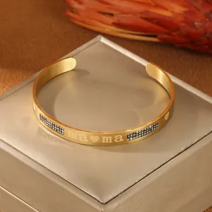 Dettaglio macro del bracciale dorato con incisione mama e cristalli neri su scatola