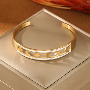 Dettaglio del bracciale rigido dorato con stelle e lune e cristalli pavé in acciaio