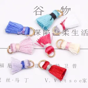 Flat lay of colorful handmade tassel pendants with gold metal rings for DIY jewelry making