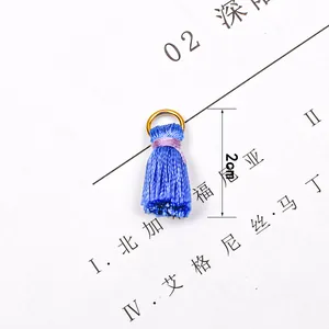 Detailed close-up of a 2cm blue tassel pendant with gold hanging ring for DIY jewelry making