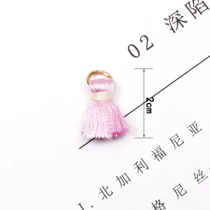Detailed view of a 2cm pink silk tassel with a golden metal ring for DIY jewelry making