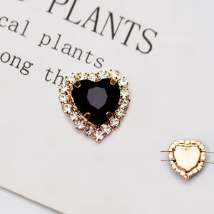 Dettaglio di un cristallo a cuore nero con strass e base in metallo dorato
