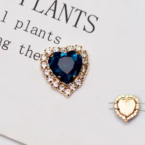 Dettaglio di strass a cuore in cristallo blu scuro con base in metallo dorato