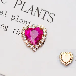 Dettaglio di pietra cuore in cristallo fucsia con doppio halo di strass e base dorata
