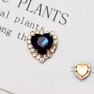 Dettaglio di strass a cuore blu scuro da cucire con base in metallo dorato e fori passanti