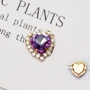 Dettaglio del cristallo di vetro viola a forma di cuore con base in metallo dorato da cucire
