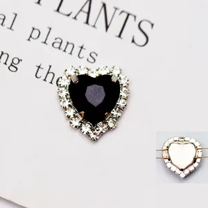 Dettaglio di strass in cristallo nero a forma di cuore con asola in argento per cucito