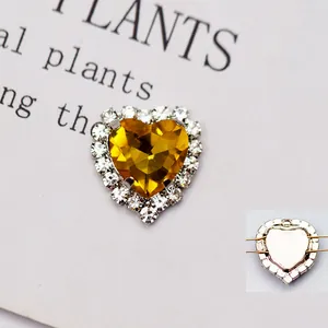 Vista macro di cristallo a cuore giallo con strass bianchi e retro in metallo traforato