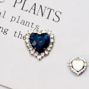 Dettaglio ciondolo a cuore in cristallo blu scuro con bordo in piccoli strass bianchi