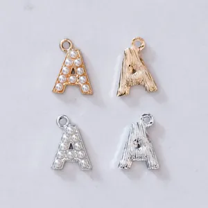 Detailansicht der goldenen und silbernen Buchstaben-A-Anhänger mit Perlen und Textur