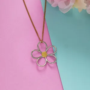 Two-tone hollow daisy pendant necklace with gold chain and silver petals on pastel background