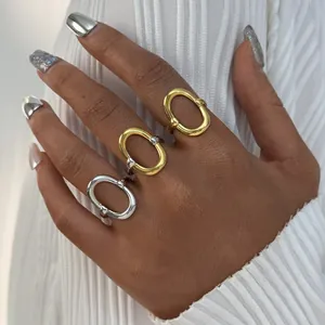 Minimalistische geometrische holle open ringen in goud en zilver op de hand getoond