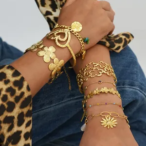 Gold hollow flower open bangle set with colorful charms on a stylish model's wrist