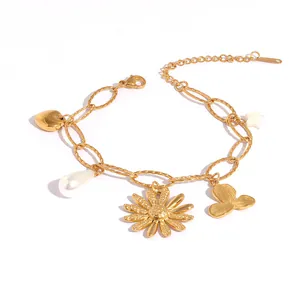 Gold chain bracelet with daisy charms, heart pendant and white pearls on white background