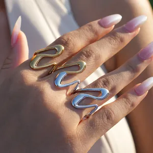 Macro shot of minimalist wave rings in gold and silver finish on model's hand