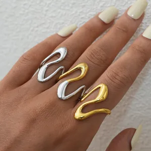 Minimalist stainless steel wave rings in gold, silver, and two-tone finishes on model