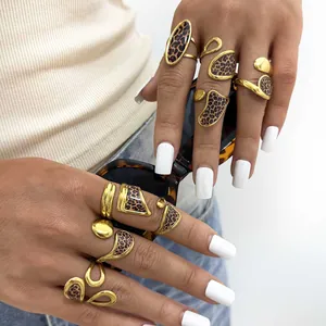 Golden geometric rings with leopard print inlay worn by a model in a trendy style