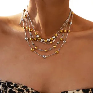 Multilayer beaded necklace with gold and silver spheres on layered metal chains