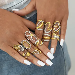Detailed view of layered irregular gold and silver ring set on a hand with denim background