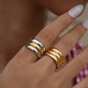 Gepolijste tweekleurige en gouden gelaagde ringen op modelhand met textuurafwerking