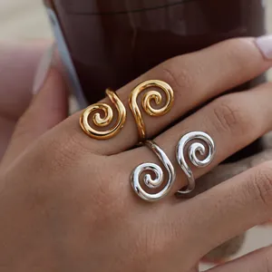 Nahaufnahme von eleganten Gold- und Silber-Spiralringen an Fingern mit glänzendem Finish