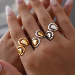 Close-up of geometric hollow open rings in gold and silver on model's hand