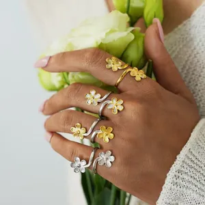 Elegant stainless steel open flower wrap ring with brushed texture on hand in gold and silver