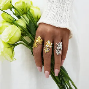 Bagues papillon élégantes en or et argent sur mains avec fleurs pour un look chic