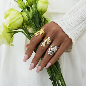 Bagues doubles papillons élégantes en or et argent portées avec des fleurs