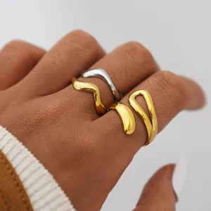 Macro shot of minimalist gold and silver wavy stainless steel rings set on hand