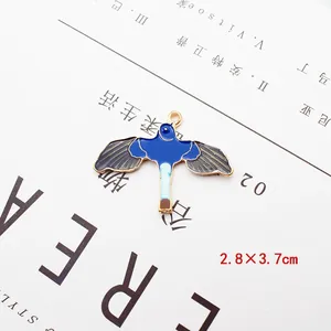 Macro-opname van 2,8x3,7 cm vogelvormige emaille hanger met gouden randen en blauwe details