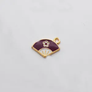 Vista macro del colgante de abanico en esmalte violeta y blanco con borde dorado para joyería DIY