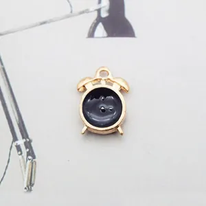 Detail eines goldenen Wecker-Anhängers mit schwarzer Emaille für DIY-Schmuckzubehör