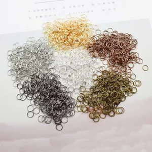 Assorted jewelry jump rings in various metal finishes on a decorative background