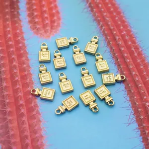 Pendentifs bouteille de parfum dorés avec anneaux pour bijoux DIY sur fond bleu