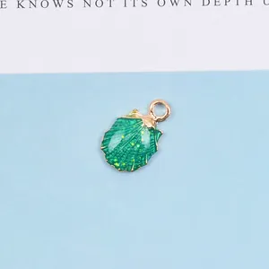 Detail eines grünen Muschelanhängers mit Vergoldung und Glitzer für DIY-Schmuck