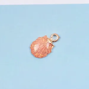 Detailaufnahme der orangefarbenen Muschelform mit Goldglitzer und Metallrand