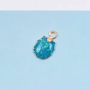Detail eines muschelförmigen Anhängers mit tiefblauem Emaille und Goldglitzer für DIY-Schmuck