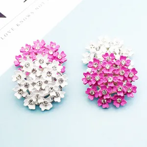 Blumen-Emaille-Brosche mit weißen und rosa Blüten und Strasssteinen auf blauem Grund