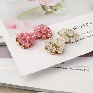 Makro-Detail von Strass-Blumenohrringen in Pink und Weiß mit mattem Finish